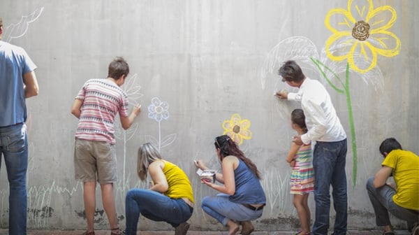 People painting flowers on a wall